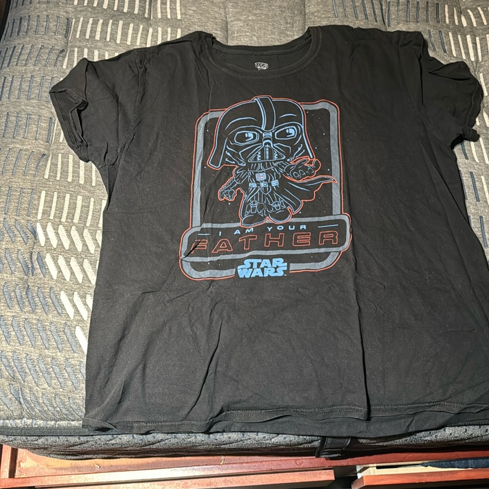 It’s a black T-shirt. Funko popped dark Vader themed. The size is XL.